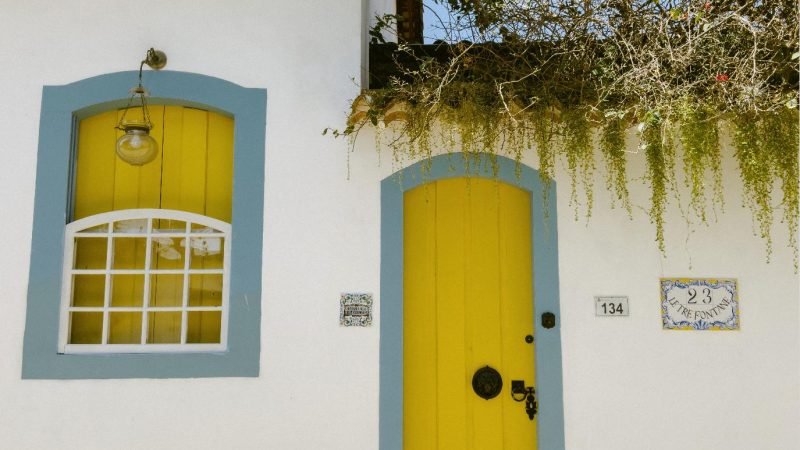 Detalhe de porta amarela e janela em fachada colonial de Paraty